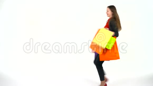 女购物者拿着白色背景的五彩购物袋在工作室让去购物吧视频的预览图