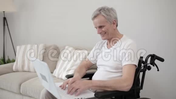 坐轮椅的残疾人在笔记本电脑上打字视频的预览图