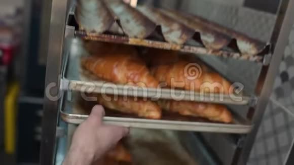 面包师手拿出一张铁烤片上面有新鲜的烘焙食品视频的预览图