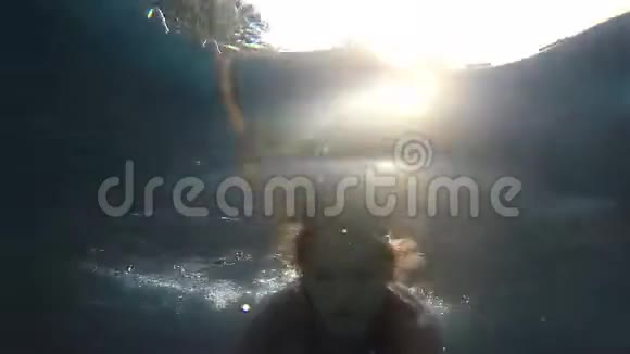 年轻漂亮的女人正在水下游泳在阳光下缓慢地拍摄1920x1080视频的预览图