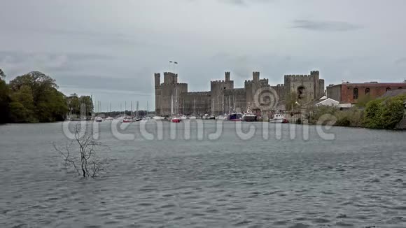 卡纳丰城堡在涨潮时停泊着许多船只视频的预览图