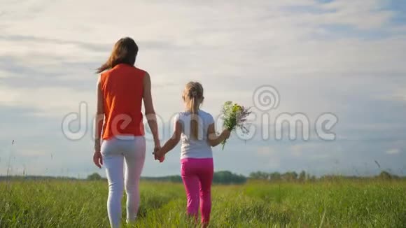 妈妈和女儿在一片花田里幸福的家庭母子女儿在花上玩得很开心快乐的女儿视频的预览图
