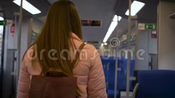 年轻漂亮的女人在火车上坐在乘客椅上带眼镜长发粉色夹克视频的预览图