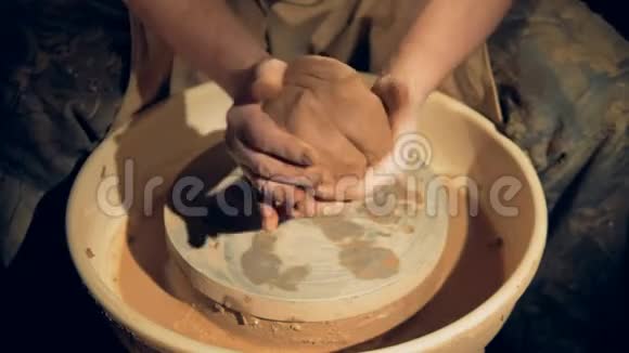 陶工用手在车轮上塑造粘土块视频的预览图