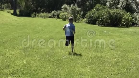 有魅力的男孩沿着公园的草地跑步心情很好慢动作视频的预览图