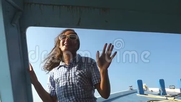 年轻女子戴着太阳镜在游艇上跳舞背景是夕阳享受海上游轮派对视频的预览图