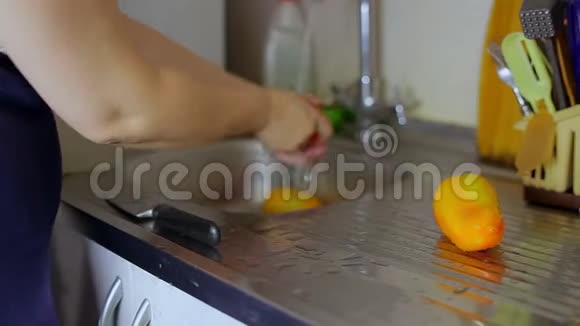 把家庭主妇的手放在水龙头下洗辣椒摄像机右侧视频的预览图