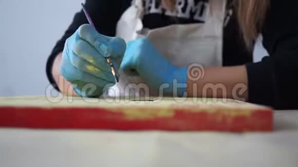 女孩艺术家在彩色板上画字母手套的手工艺视频的预览图