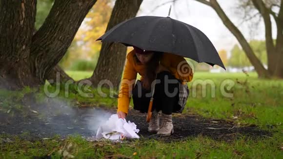 公园里雨中被火取暖的女人视频的预览图
