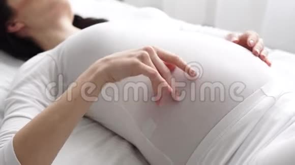 孕妇抚摸婴儿腹部特写视频的预览图