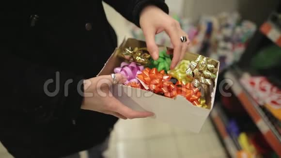 圣诞妇女买树装饰一个年轻有魅力的女孩在新年礼物中选择蝴蝶结视频的预览图