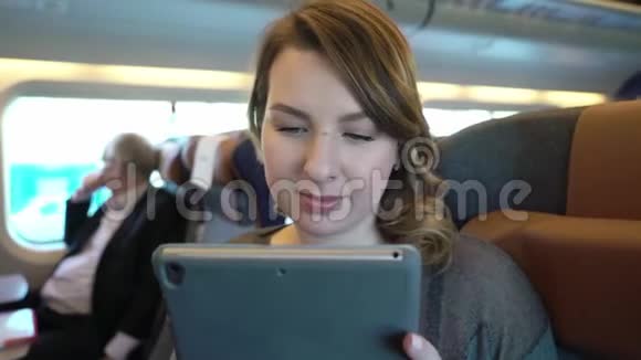 年轻女孩使用平板电脑上网火车乘客视频的预览图