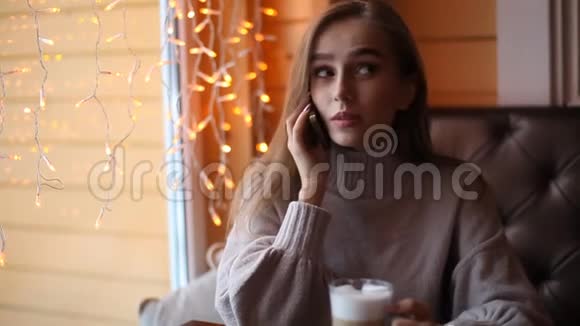 年轻的女人在咖啡馆里打电话喝咖啡博克背景视频的预览图
