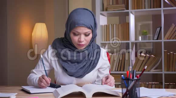 穆斯林成年女医生戴头巾在室内图书馆参加体检的特写镜头视频的预览图