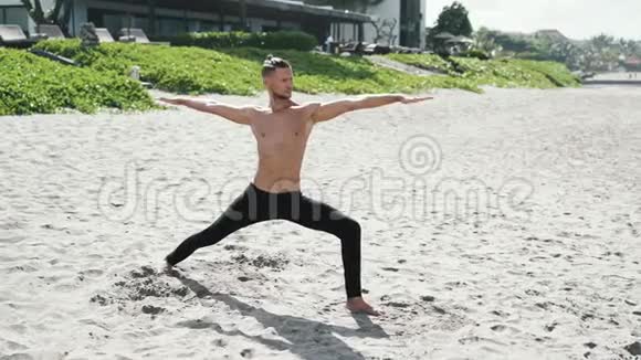 慢动作稳定射击运动赤膊男子在沙滩上做伸展运动视频的预览图