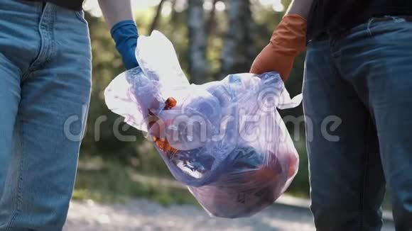 两名志愿者在清理森林后拿出垃圾和回收塑料瓶视频的预览图