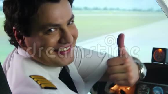 男飞行员在驾驶舱里微笑竖起大拇指举着手势空中交通视频的预览图