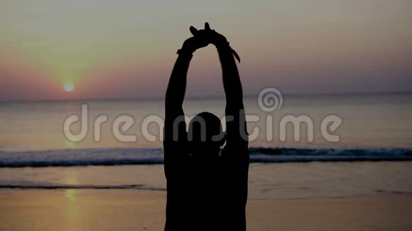 日落时人在海滩上的剪影视频的预览图