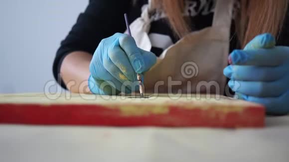 女孩艺术家在彩色板上画字母手套的手工艺视频的预览图