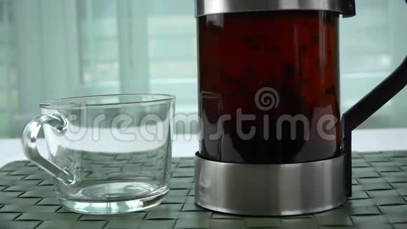 一个装有浓茶的玻璃茶壶放在茶杯旁边视频的预览图