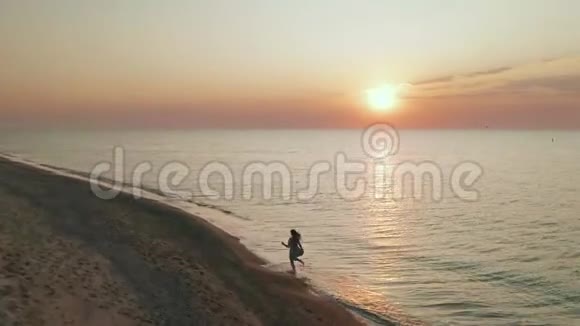 苗条运动的女人一大早就独自在海岸上跑步空中景观视频的预览图