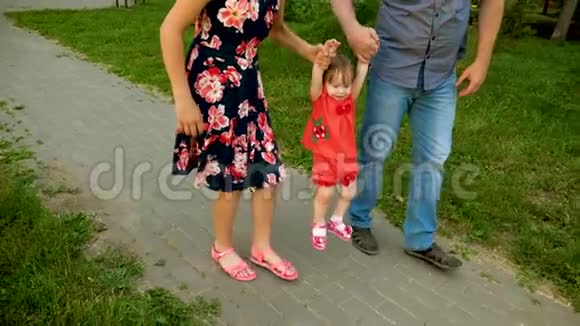 爸爸妈妈正牵着小幸福和微笑的宝宝手走来走去一家人在玩小孩走路视频的预览图