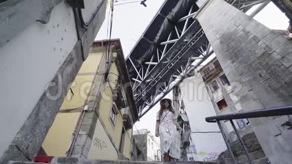 穿着休闲装的女人走在桥下大街上视频的预览图