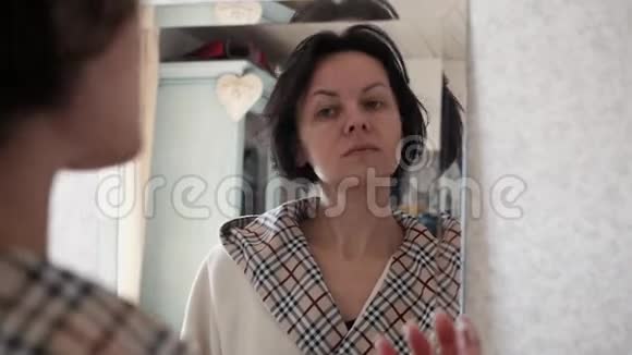 美丽健康女性脸上涂保湿霜的肖像视频的预览图