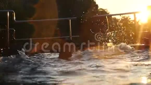 年轻人在热带度假胜地美丽的夕阳下在游泳池里游泳假期概念慢动作1920x1080视频的预览图