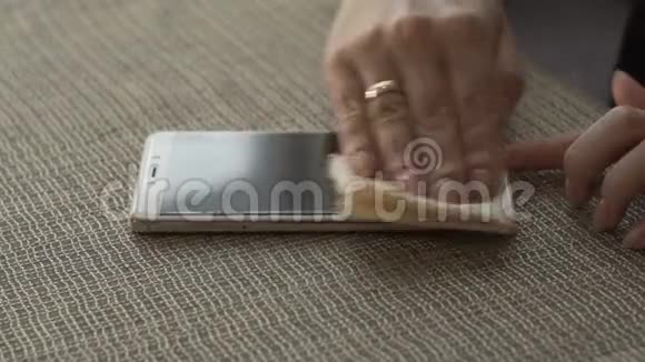 女性用手擦拭表面屏幕手机用布贴近视频的预览图