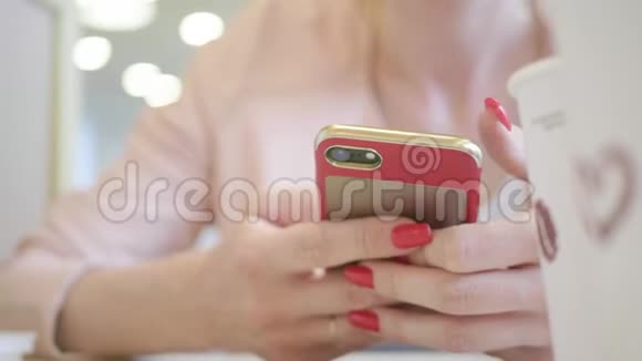 年轻女性在工作休息时坐在舒适的咖啡店里用手机迷人的快乐女性阅读视频的预览图