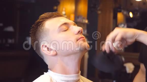 男理发师在理发店给他的男客户做美容手术口渴的过程慢动作关闭视频的预览图