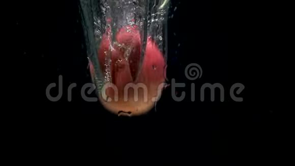黑色背景下红苹果在水中坠落的视频视频的预览图