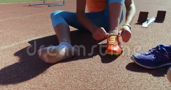女运动员在运动场系鞋带4k视频的预览图