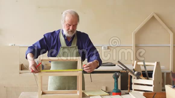 老灰头发的木匠胡子和胡须测量木制娃娃屋视频的预览图