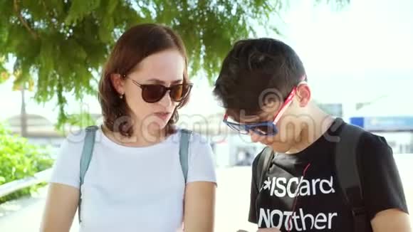 一个带助听器的家伙正在和街上的一个女人说话妈妈和儿子在街上交流4k视频的预览图