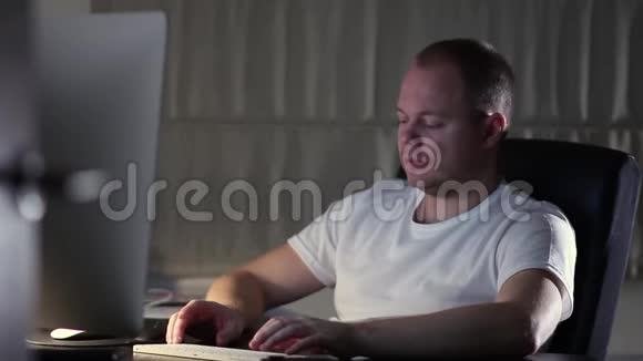 一个穿T恤的男人在家里电脑工作视频的预览图