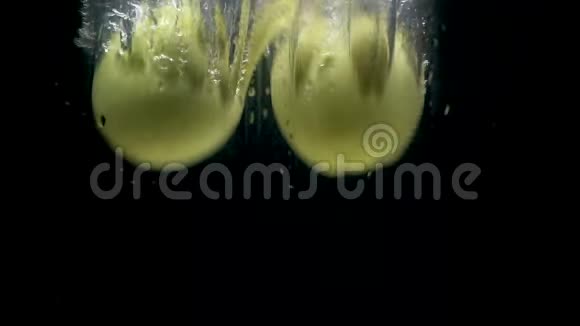 黑色背景下的水中绿苹果视频视频的预览图
