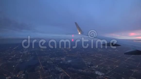 从飞机上看到机翼晚上飞过城市灯光和街道视频的预览图
