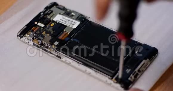 修理工用螺丝刀拆卸智能手机修理坏电话的技术员电子修理服务视频的预览图