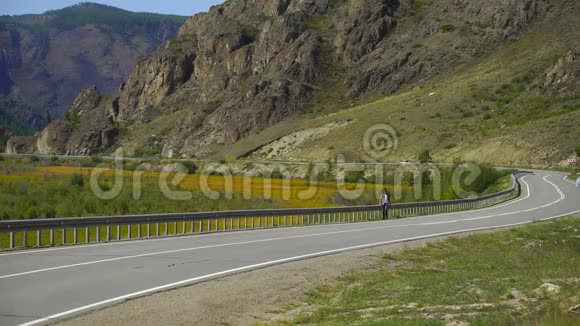 年轻的旅行者背着背包独自走在山上的路上他在路上旅行4千克视频的预览图