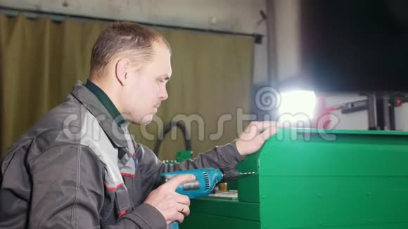 工厂的技术员用手电钻修理机器视频的预览图