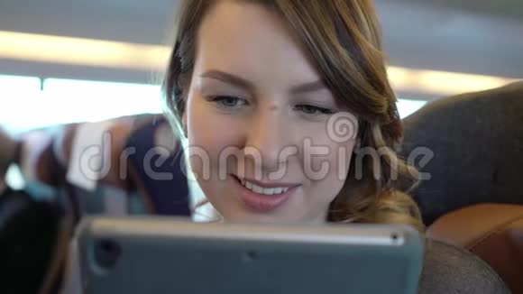 年轻女孩使用平板电脑上网火车乘客视频的预览图