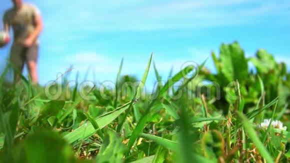 草地上的镜头慢镜头特写夏天在蓝天草地上玩球的人视频的预览图