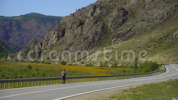 年轻的旅行者背着背包独自走在山上的路上他在路上旅行4千克视频的预览图