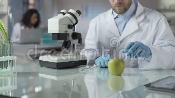 实验室助理给苹果注射部分农药以适应市场条件视频的预览图