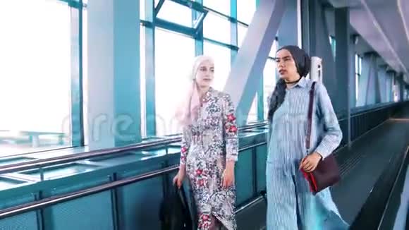 两名穆斯林妇女乘坐自动扶梯前往机场视频的预览图