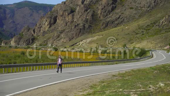 年轻的旅行者背着背包独自走在山上的路上他在路上旅行4千克视频的预览图