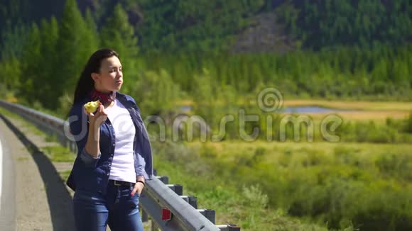 年轻漂亮的女旅行者在山上吃苹果4千克视频的预览图