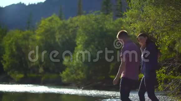 青年男女在山河里洗手在群山的背景上喷洒4千克视频的预览图